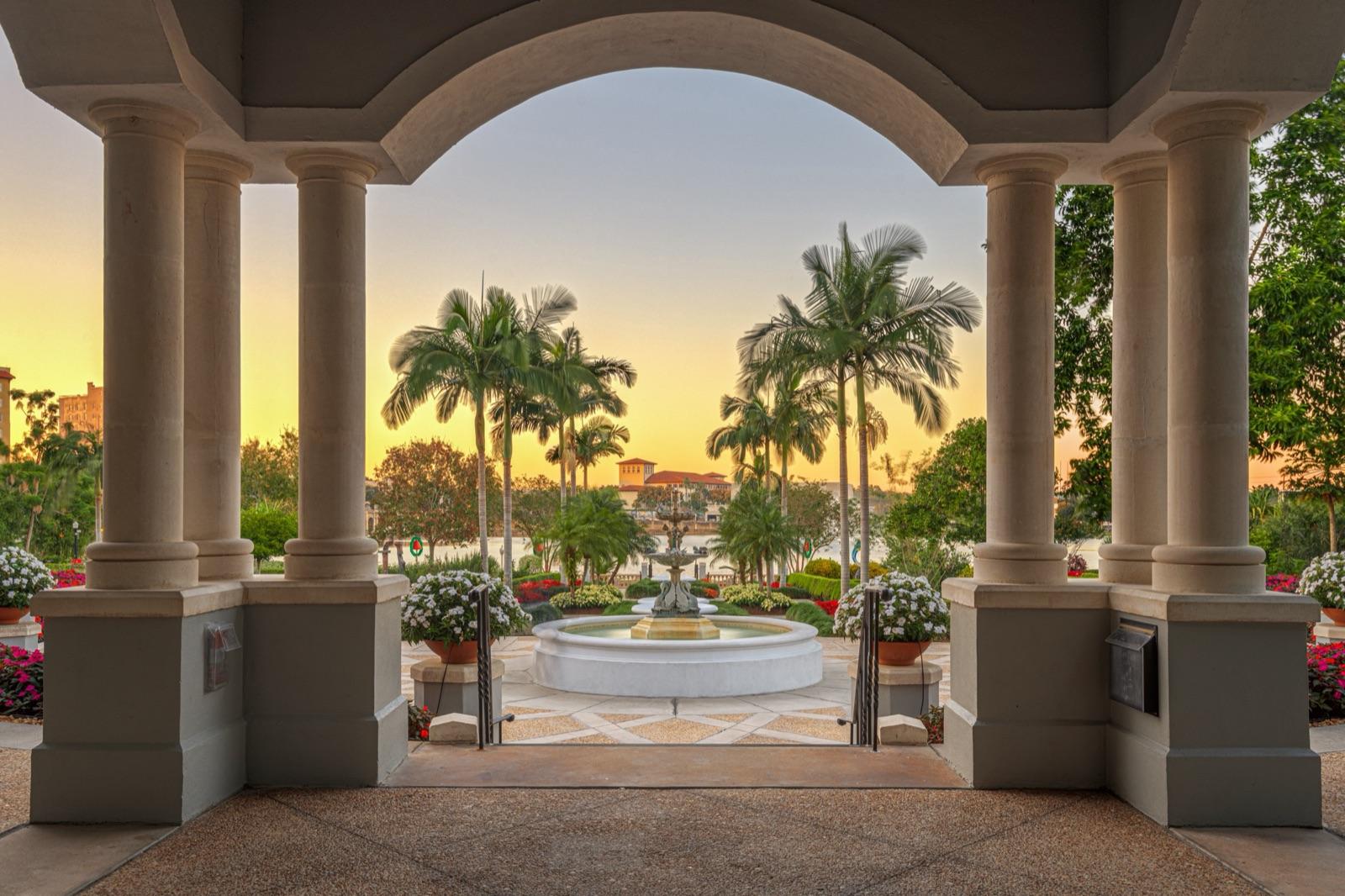 Stone colonnade opening onto a Florida garden courtyard with a fountain
